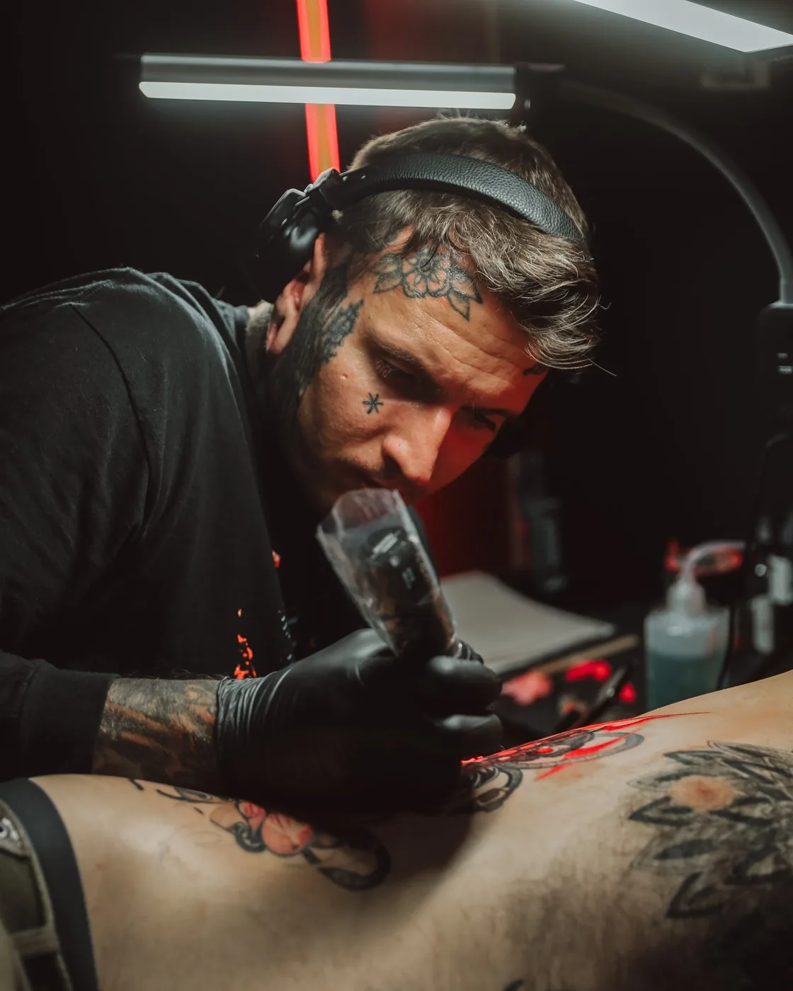 Alex Roze tattooing in the studio