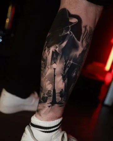 Film-noir street scene leg — black & grey tattoo by Alex Roze, Kelowna