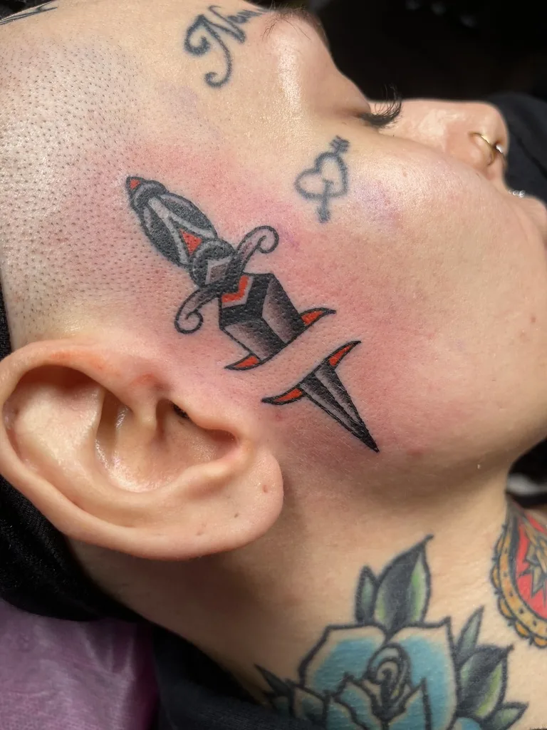Dagger on the face — traditional tattoo by Alex Roze, Kelowna