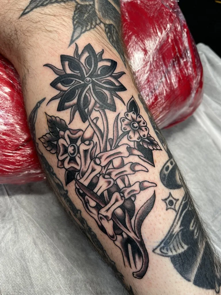 Traditional skeleton hand with flowers — traditional tattoo by Alex Roze, Kelowna