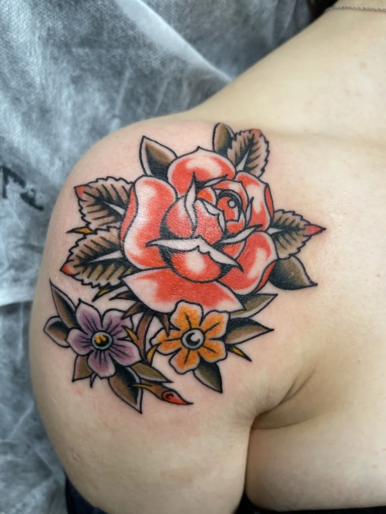 Rose and flowers on the shoulder — traditional tattoo by Alex Roze, Kelowna