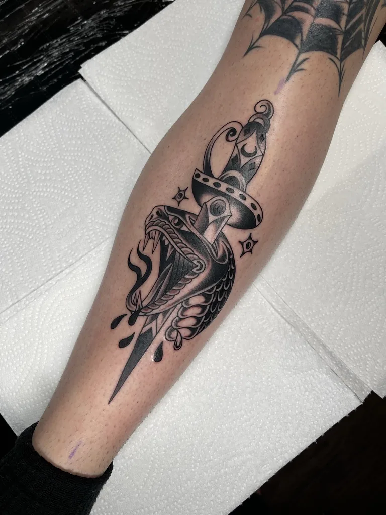 Bird head pierced by a dagger — traditional tattoo by Alex Roze, Kelowna