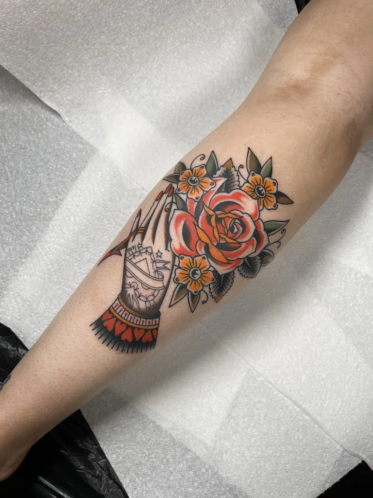 Hand holding a red rose — traditional tattoo by Alex Roze, Kelowna