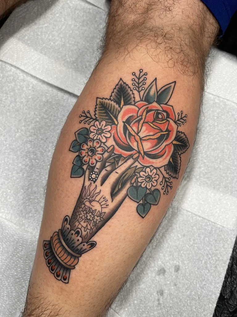 Hand holding a rose and flowers — traditional tattoo by Alex Roze, Kelowna