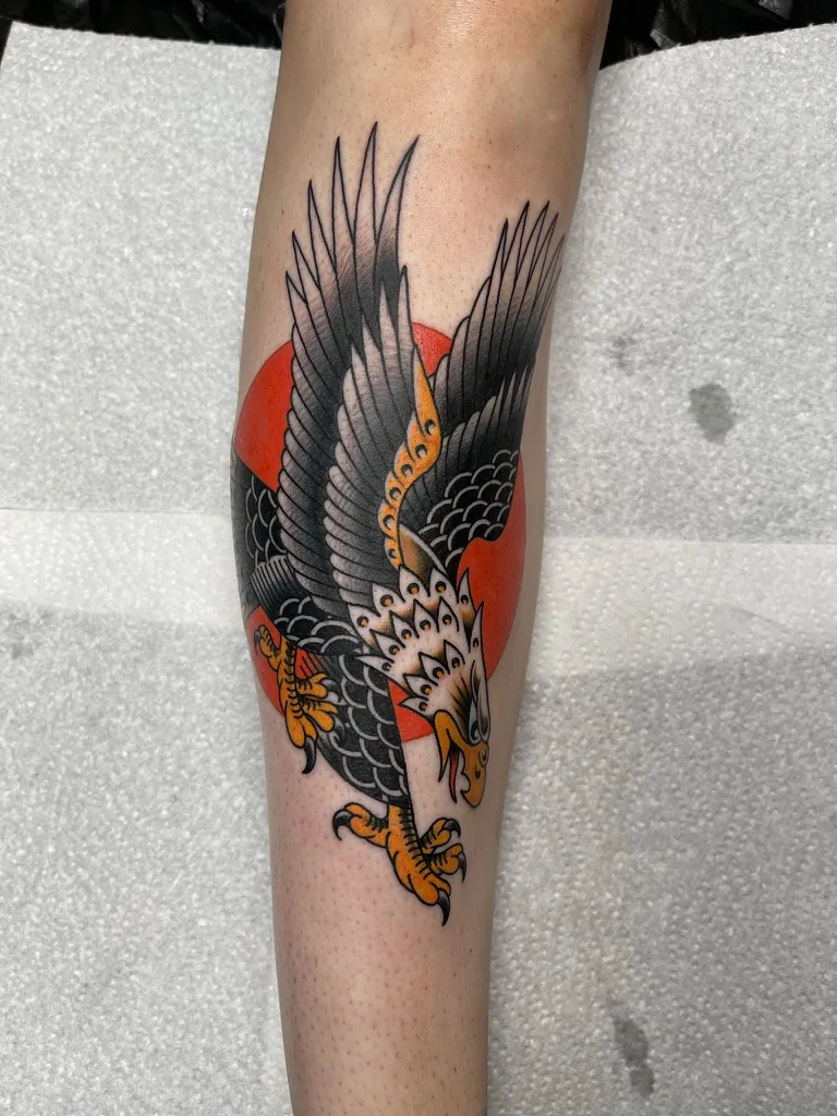 Eagle over a red sun on the lower leg — traditional tattoo by Alex Roze, Kelowna