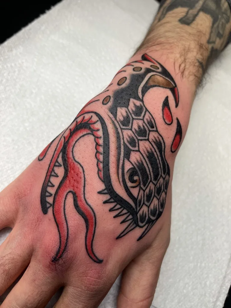 Winged one-eyed creature on the hand — traditional tattoo by Alex Roze, Kelowna