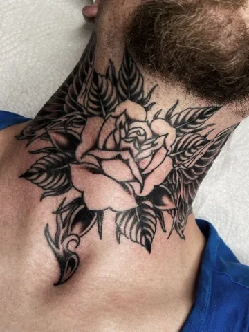 Black and grey rose with leaves on the neck — traditional tattoo by Alex Roze, Kelowna