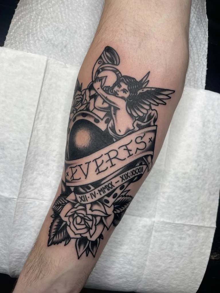 Cherub, horseshoe, roses and banner — traditional tattoo by Alex Roze, Kelowna