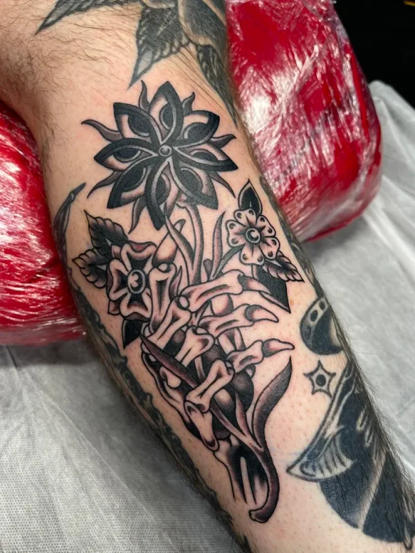 Traditional skeleton hand with flowers. Tattoo by Alex Roze.