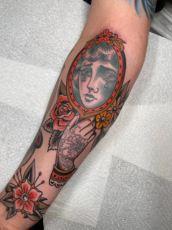 Lady crying into a hand mirror. Tattoo by Alex Roze.