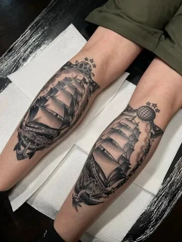 Two clipper ships on the calves. Tattoo by Alex Roze.