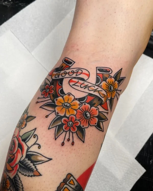 Good Luck horseshoe with flowers. Tattoo by Alex Roze.